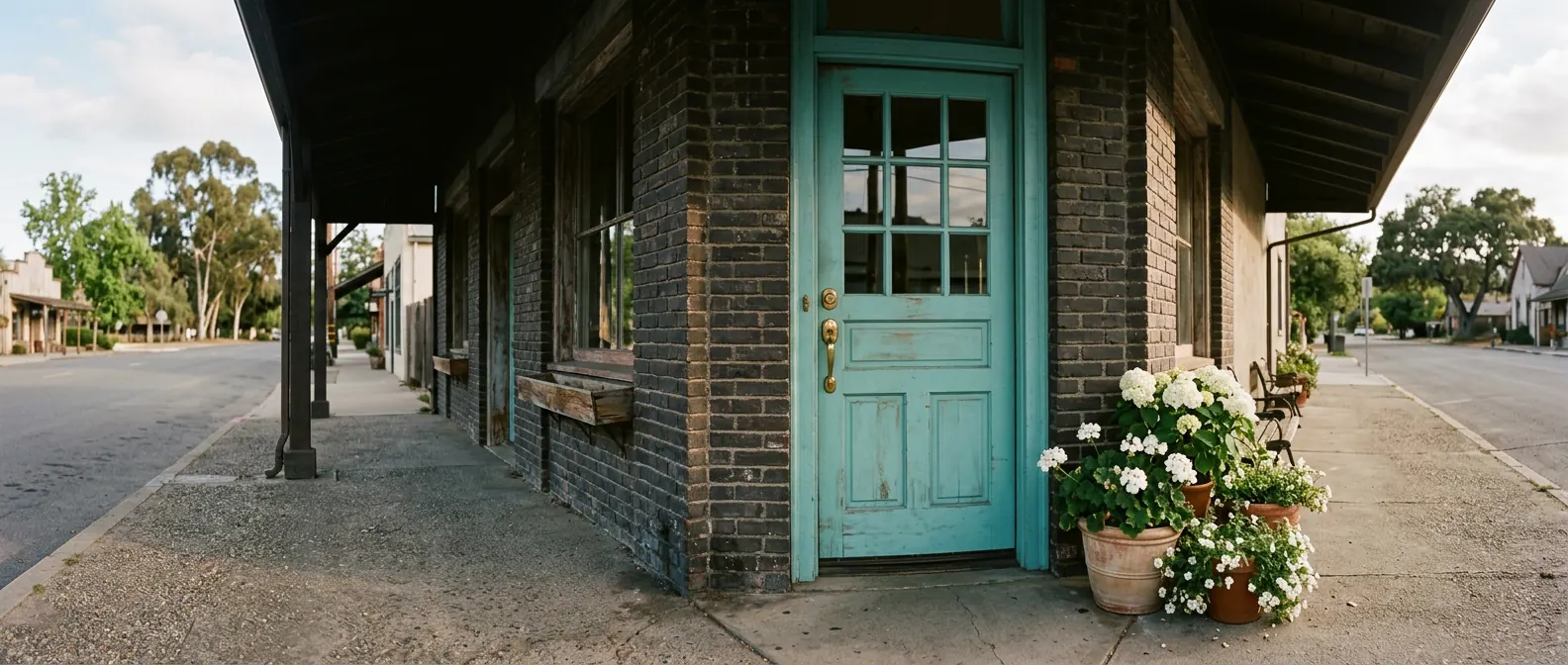 Turquoise front door with white potted flowers at a Petaluma storefront